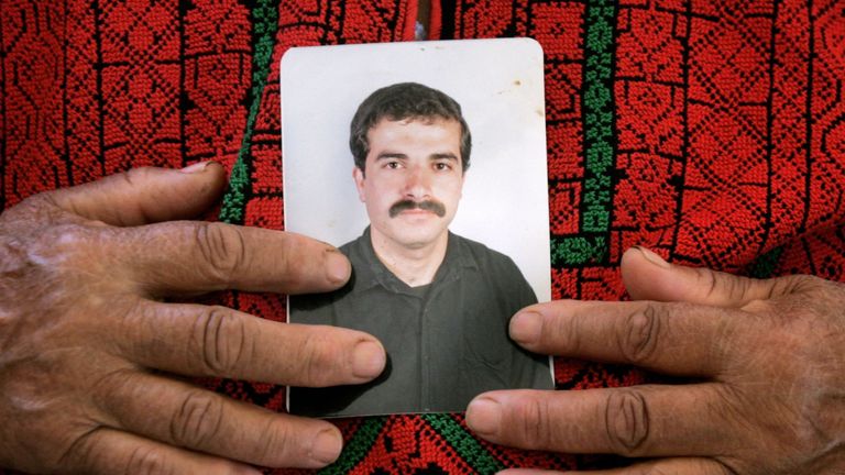 Ibrahim Hamed's mother holds his portrait at the family house in the West Bank village of Silwad near Ramallahin 2006. File pic: AP