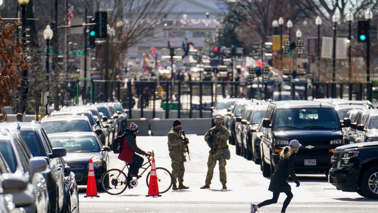 National Guard troops patrol a closed street near the White House as security tightens ahead of presidential inaugural events in Washington, U.S., January 17, 2021. REUTERS/Erin Scott