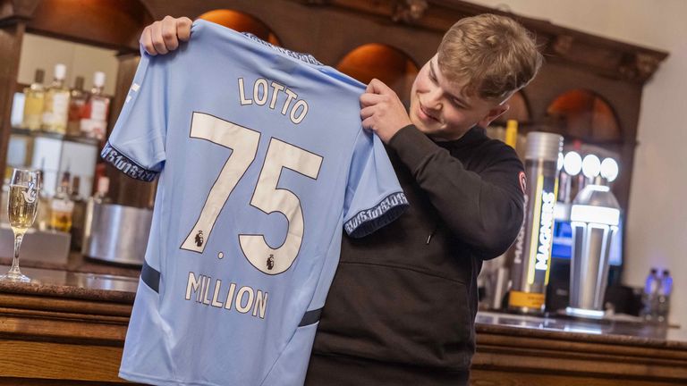 James Clarkson holds bespoke Manchester City kit after lotto win. Pic: PA