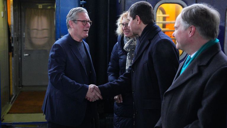 The PM was greeted by Ukrainian officials and the British ambassador to Ukraine Martin Harris (right) as he arrived at Kyive train station. Pic: PA