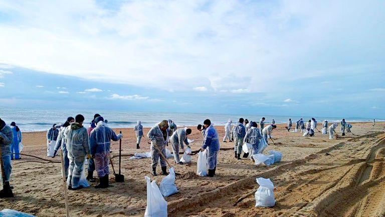 In this photo released by Krasnodar Gov. Veniamin Kondratyev in his Telegram channel on Sunday, Jan. 5, 2025, rescuers and volunteers work to clean up tons of fuel oil that spilled out of two storm-stricken tankers more than two weeks ago in the Kerch Strait, near Anapa in Russia's southern Krasnodar region. (Krasnodar Gov. Veniamin Kondratyev Telegram channel via AP)