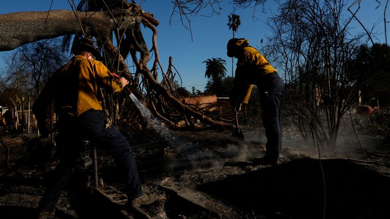 Firefighters put out a smouldering hot spot. Pic: Reuters