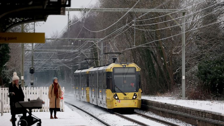 Commuters wait for a tram on a snow-covered platform in Manchester.
Pic: Reuters