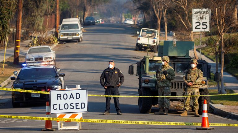 National Guards stand near the damaged structures burned from the Eaton Fire in Altadena, California, U.S., January 10, 2025. REUTERS/Ringo Chiu