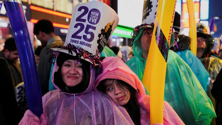 People react at Times Square during New Year's Eve celebrations in New York City, U.S., December 31, 2024. REUTERS/Adam Gray