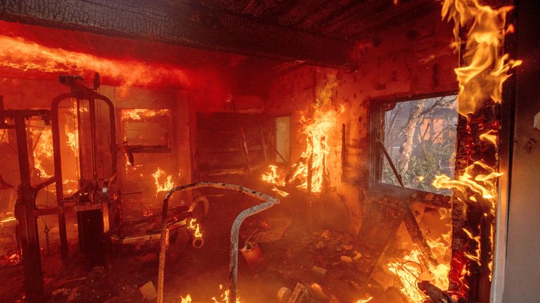 The Palisades Fire burns a residence in the Pacific Palisades neighborhood of Los Angeles, Tuesday, Jan. 7, 2025. (AP Photo/Ethan Swope)