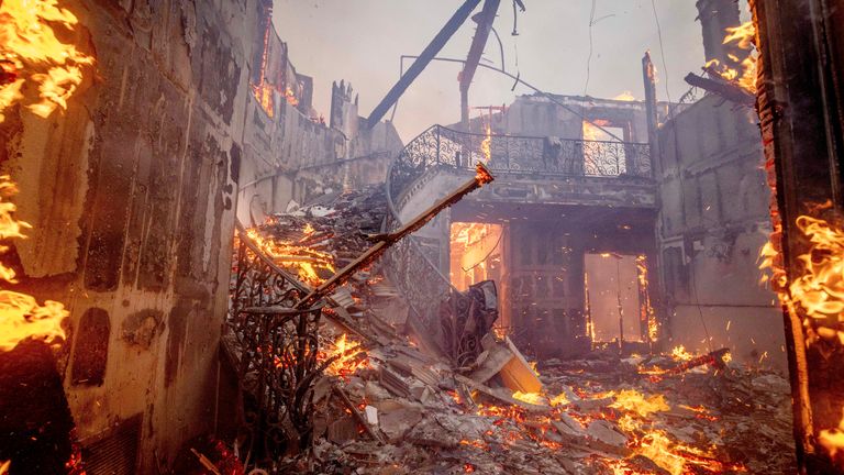 The Palisades Fire burns a residence in the Pacific Palisades neighborhood of Los Angeles, Tuesday, Jan. 7, 2025. (AP Photo/Ethan Swope)