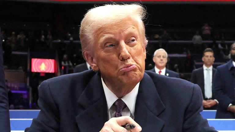 Donald Trump reacts as he signs an executive order during the inaugural parade inside Capital One Arena on the inauguration day of his second presidential term, in Washington, U.S. January 20, 2025. REUTERS/Carlos Barria