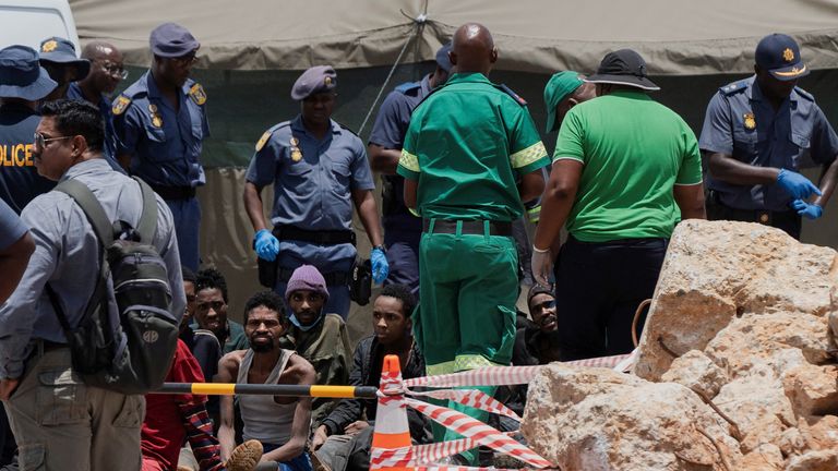 Rescued miners are seen as they are processed by police after being rescued at the mine shaft.
PIc: Reuters