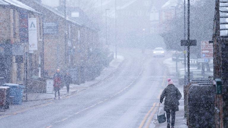 A woman walks through heavy snowfall on the high street of Saddleworth.
Pic: AP