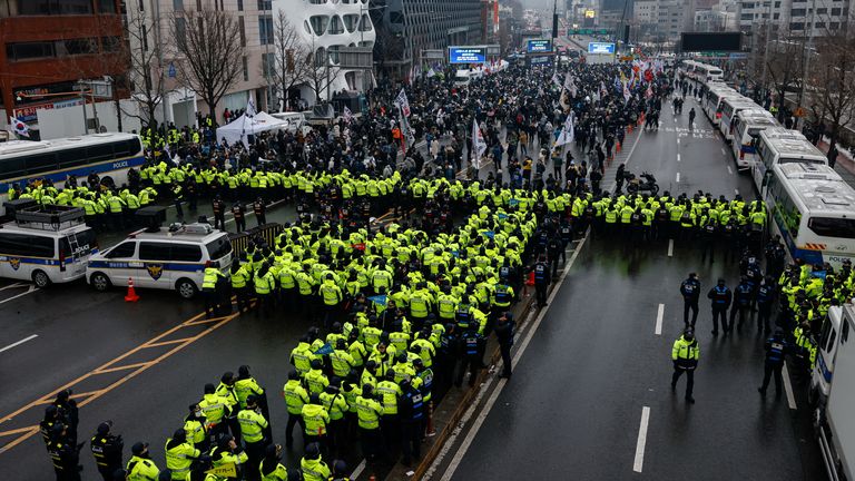 Police stand guard, blocking the road leading to the official residence of impeached South Korean President Yoon Suk Yeol as protesters gather, in Seoul, South Korea, January 5, 2025. REUTERS/Tyrone Siu