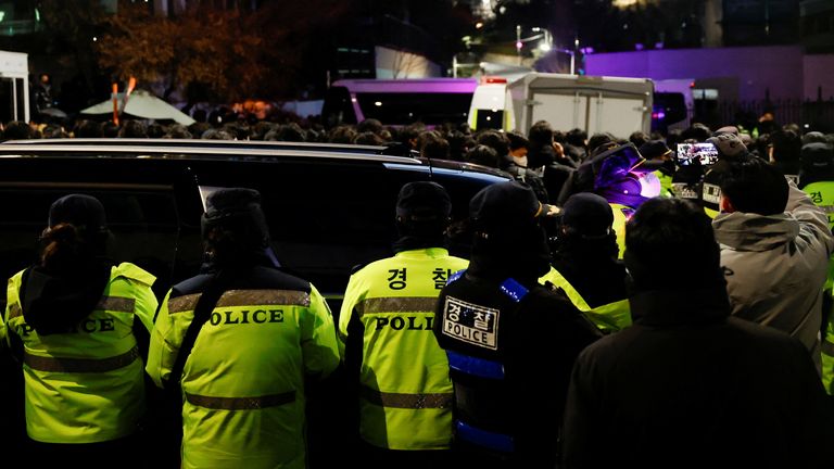 Police officers gather near the official residence of impeached South Korean President Yoon Suk Yeol, as authorities, including the Corruption Investigation Office for High-ranking Officials, are seeking to execute an arrest warrant, in Seoul, South Korea, January 15, 2025. REUTERS/Tyrone Siu