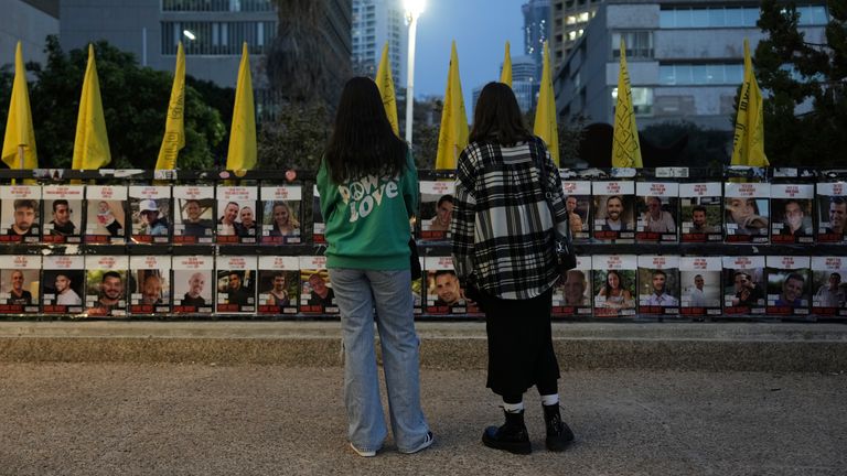 Two women look at photos of the hostages held in Gaza. Pic: AP Photo/Oded Balilty