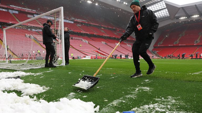 Groundsmen set up the goal nets and clear the pitch of snow inside Anfield ahead of Liverpool's match against Manchester United. Pic: Reuters 