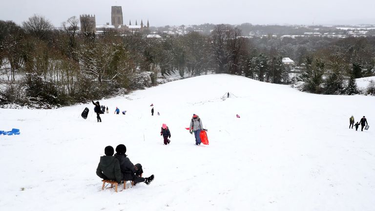 Members of the public are seen sledging on a hill near Durham Cathedral. Pic: AP