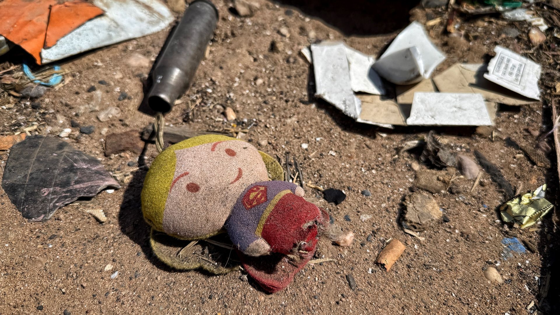 Inside the war-torn city where toys and childrens' photos litter the street next to ammunition