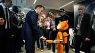 French President Emmanuel Macron bumps fists with a robot during the Paris AI summit. Pic: Reuters
