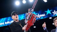 Elon Musk holds a chainsaw gifted by Argentina  president Javier Milei during the Conservative Political Action Conference.
Pic: Reuters
