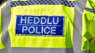 Cardiff, Wales - March 2022: Rear view of the bilingual sign on the jacket of a police officer on duty in Cardiff city centre