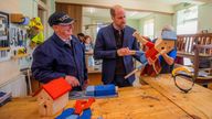 Britain's Prince William, The Duke of Rothesay stands alongside Alex Campbell and Derek Stewart who show him how to make a ''Tree-Hugger'' at the Carnoustie and Monifieth Men's Shed.
Pic: Reuters