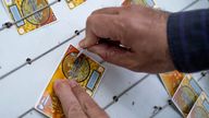 A man scratching ticket of Turkish lottery in the street at the stand of a lottery ticket seller. Pic: iStock