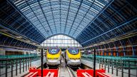 London, United Kingdom - August 30, 2015: Two huge bright red steel buffer stops protect the Eurostar terminus at St Pancras Station in London as three trains wait in platforms for their turn to take passengers on the high speed journey to Paris via the Chunnel. Opened in 1868, this masterpiece of Gothic architecture underwent a magnificent restoration completed in late 2007.