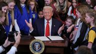 Donald Trump holds up a signed executive order banning transgender girls and women from participating in women's sports. Pic: Reuters