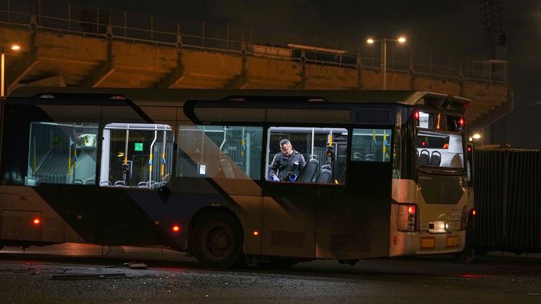 An Israeli police officer inspects a bus after a series of explosions. Pic: AP