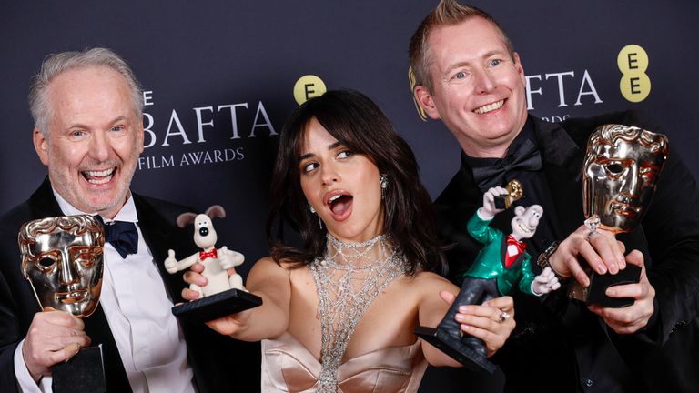 Nick Park, left, Merlin Crossingham, right, and presenter Camila Cabello, pose with the award for best children's family film at the 78th British Academy Film Awards, BAFTA's, in London, Sunday, Feb. 16, 2025. (Photo by Joel C Ryan/Invision/AP)