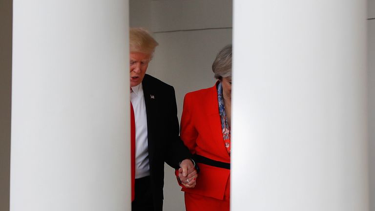 Donald Trump holds then British Prime Minister Theresa May's hand as they walk along the colonnades of the White House in Washington in January 2017. Pic: AP