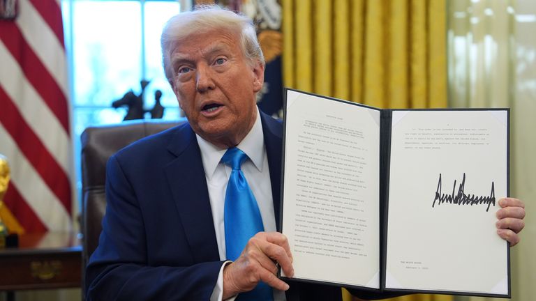 President Donald Trump holds an executive order regarding withdrawing from the United Nationals Human Rights Council in the Oval Office of the White House, Tuesday, Feb. 4, 2025, in Washington. (AP Photo/Evan Vucci)