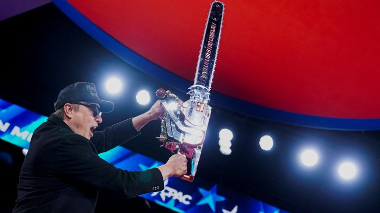 Elon Musk holds up a chainsaw on stage during a conservative conference in Maryland. Pic: Reuters