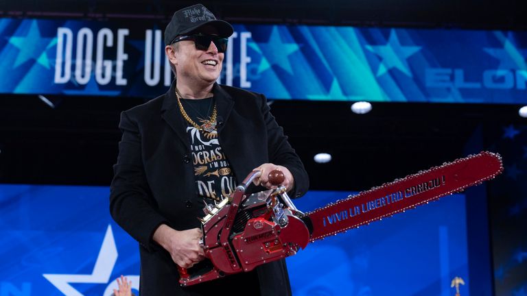 Elon Musk hold a chainsaw as he arrives to speak at the Conservative Political Action Conference, CPAC, at the Gaylord National Resort & Convention Center, Thursday, Feb. 20, 2025, in Oxon Hill, Md. (AP Photo/Jose Luis Magana)