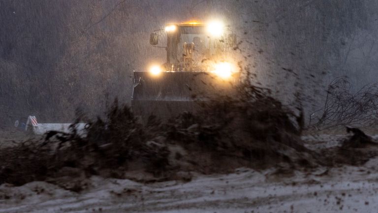 Mud flows down a road during a flash flood as a bulldozer clears debris in the Eaton Fire zone in Altadena, California. Pic: AP