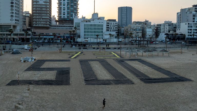 Relatives and supporters of Israelis held hostage by Hamas in Gaza mark 500 days of their captivity with the numbers 500 laid out on the beach in Tel Aviv. Pic: AP