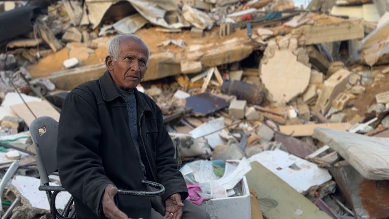 Abu Samir sits among rubble