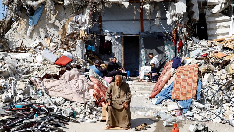 Palestinians sit among the rubble of buildings destroyed by Israel as politicians try to decide the fate of the enclave, with its people trying to live on.
Pic: Reuters/Hatem Khaled