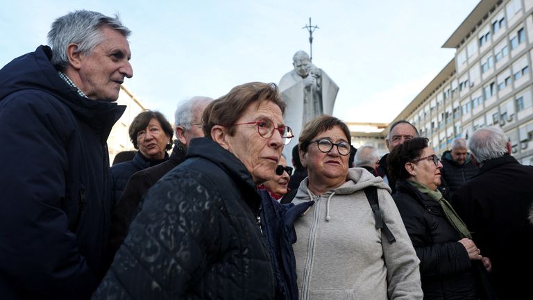 People stand before the statue of the late Pope John Paul II outside Gemelli Hospital, where Pope Francis is admitted for treatment, in Rome, Italy, 26 February 2025. Reuters/Hannah McKay