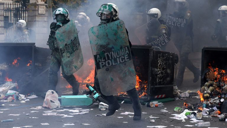 Riot police advance past burning garbage bins, during clashes with demonstrators, at a protest near the Greek parliament, marking the second anniversary of the country's worst railway disaster, while an investigation continues, in Athens, Greece, February 28, 2025. REUTERS/Florion Goga