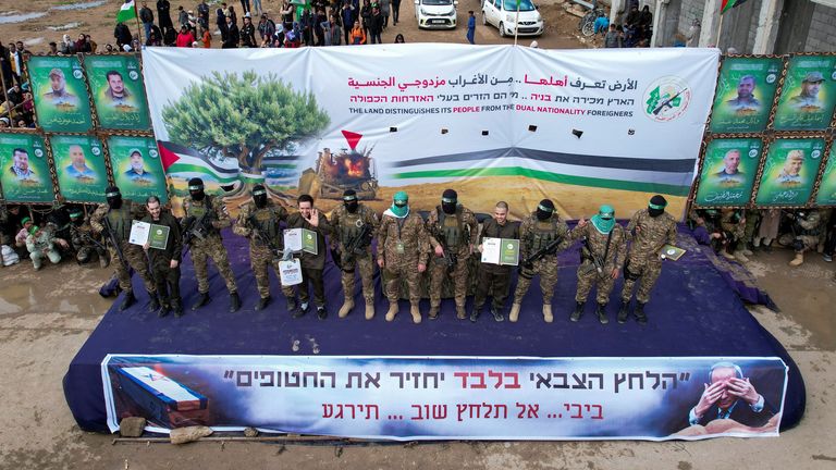 Three of the Israeli hostages on stage in Gaza as they are handed over by Hamas on Saturday. Pic: Reuters