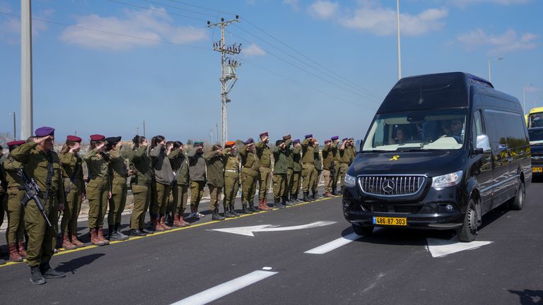 Israeli soldiers salute as the convoy carrying the coffins. Pic: AP