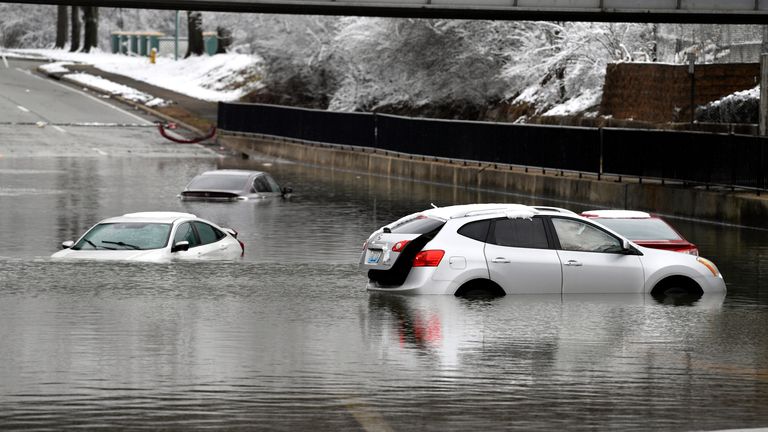 Cars sit in floodwaters at a railroad underpass in Louisville, Ky., Sunday, Feb. 16, 2025. (AP Photo/Timothy D. Easley)