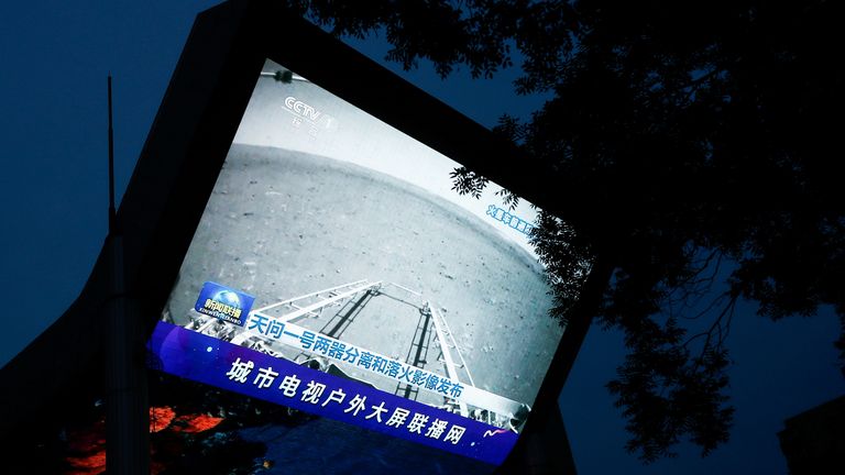 A screen broadcasts a CCTV state media news bulletin, showing an image of Mars taken by Chinese Mars rover Zhurong as part of the Tianwen-1 mission, in Beijing, China, May 19, 2021. REUTERS/Thomas Peter REFILE - CORRECTING INFORMATION