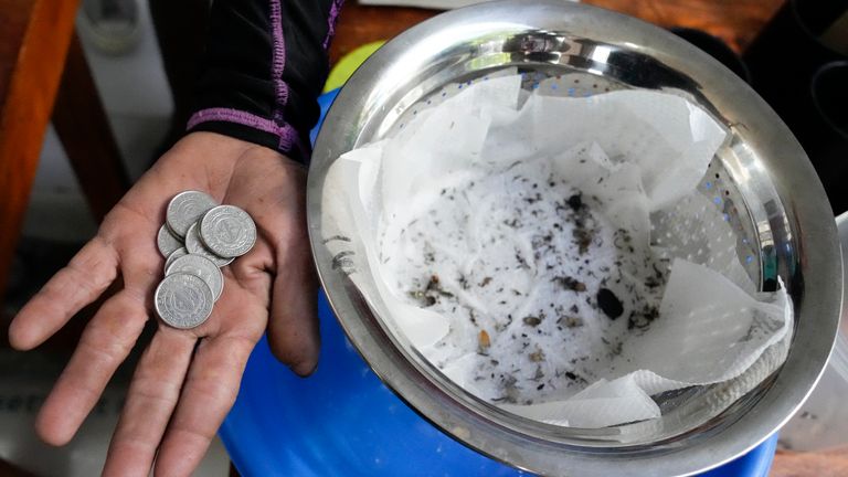 Michael Labag shows the 9 pesos reward he got from the 45 mosquito larvas he captured in Mandaluyong city, Philippines as the village started offering bounty for captured mosquitos, dead or alive, as part of an anti-dengue campaign on Wednesday, Feb. 19, 2025. (AP Photo/Aaron Favila)