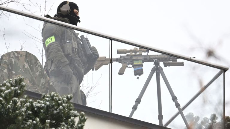 A police sniper secures the conference venue with his weapon. Pic: AP