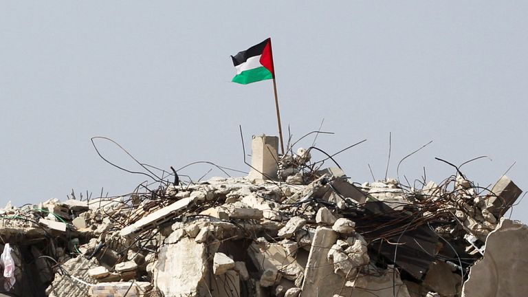 A Palestinian flag flutters among the rubble of buildings in Rafah.
Pic: Reuters