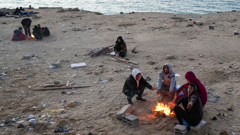 Displaced Palestinians warm themselves by a fire as they wait to return to their homes in the northern part of the Gaza Strip, Sunday, Jan. 26, 2025, days after the ceasefire deal between Israel and Hamas came into effect. (AP Photo/Abdel Kareem Hana)