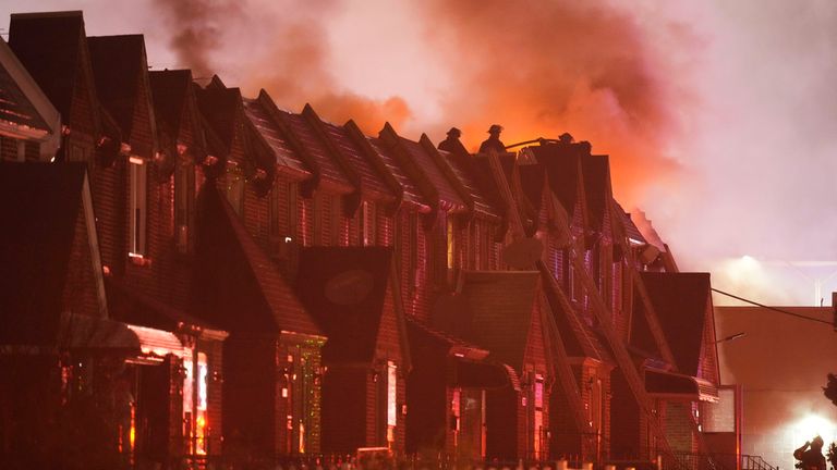 Smoke rises above houses after the plane crash in Philadelphia. Pic: AP