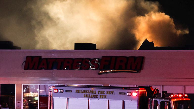 Smoke rises as emergency services work at the scene of a plane crash in Philadelphia. Pic: Reuters