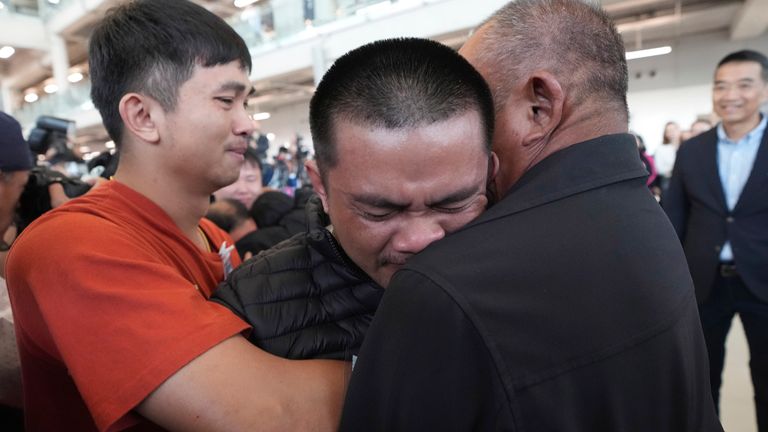 Former hostage Pongsak Thaenna, centre, hugs a relative at Suvarnabhumi Airport. Pic: AP